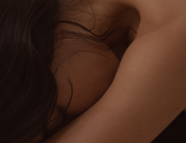 Orgasm Gap: Warum Frauen seltener Kommen als Männer Eine Person, die sich nach vorne beugt.