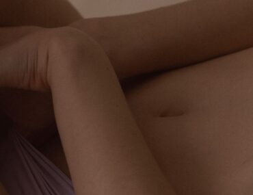 Fantasie vs. Realität: Warum Sex manchmal besser im Kopf ist Eine Person berührt sich mit den Händen im Schoß.